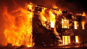 Blog 3 Building fully engulfed in flames at night, representing a New Jersey fire damage insurance claim