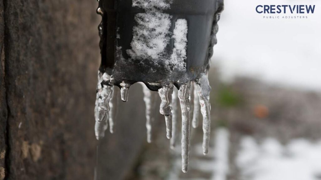 Frozen Pipe Insurance Claim In New Jersey: What To Do Before, During, And After A Burst 2 Icicles hanging from a frozen black pipe fitting covered in snow