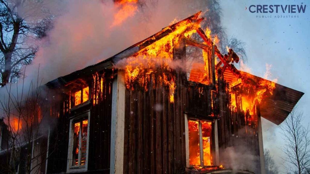 Fire Damage Insurance Claim In New Jersey: What Your Policy Covers (And What It Doesn’t) 3 Two-story wooden house fully engulfed in flames with thick smoke billowing in winter daylight
